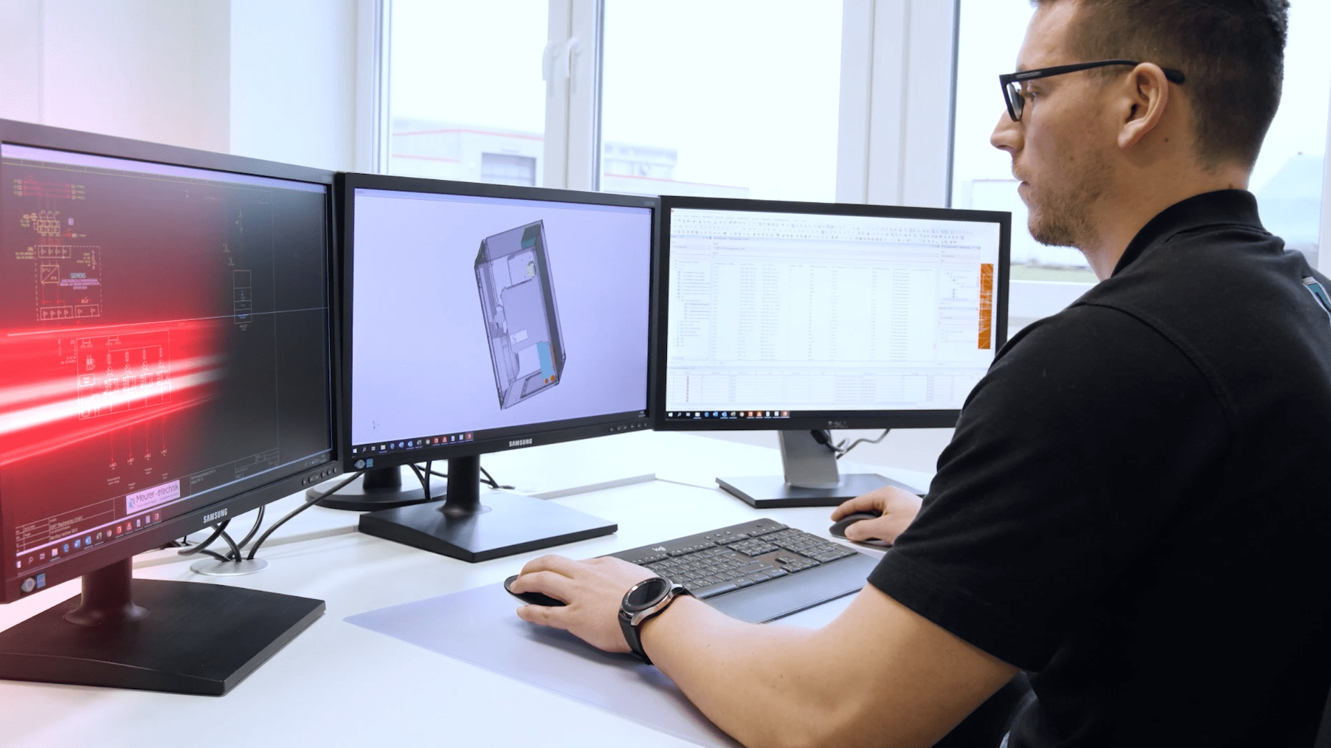 a man looking at ecad software on his monitors to reduce errors in their manufacturing process